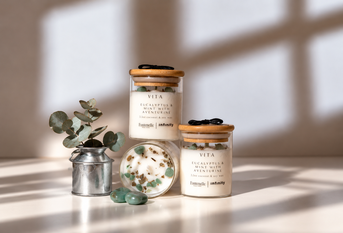 Vita Incanto candles in glass jars, styled with eucalyptus leaves and green aventurine stones