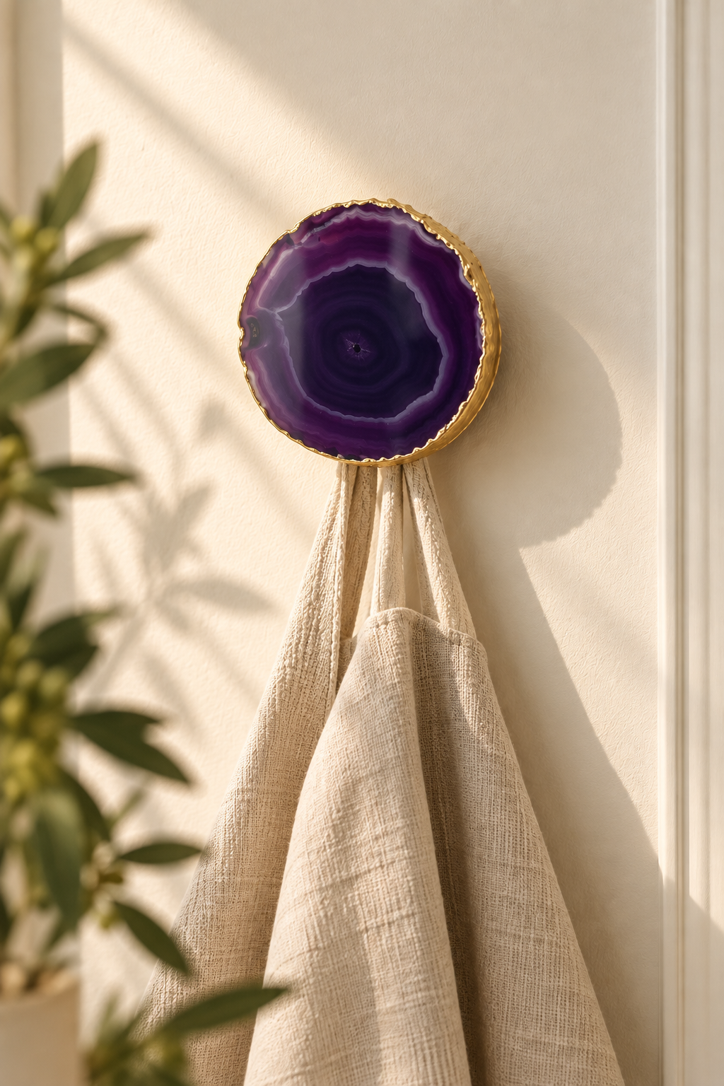 Purple natural agate wall hook with gold edge holding a linen bag